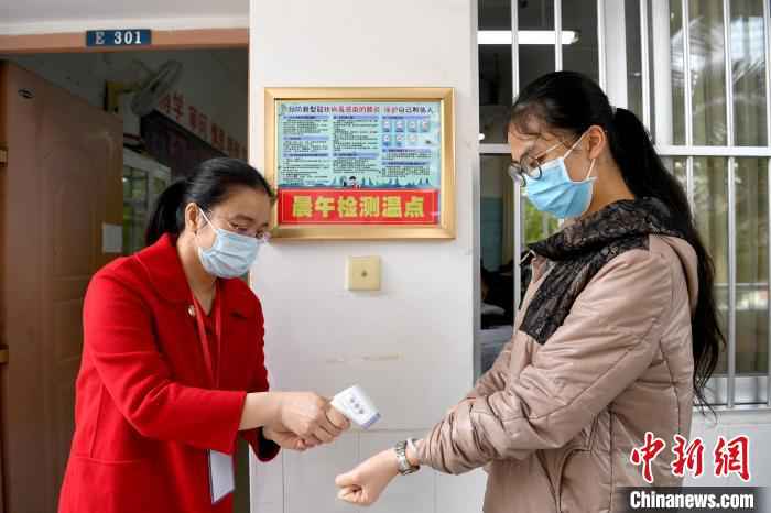 南宁市第三中学学生接受体温检测。 俞靖 摄 广西初三高三年级学生开学 抗疫专家给桂林学生上开学第一课